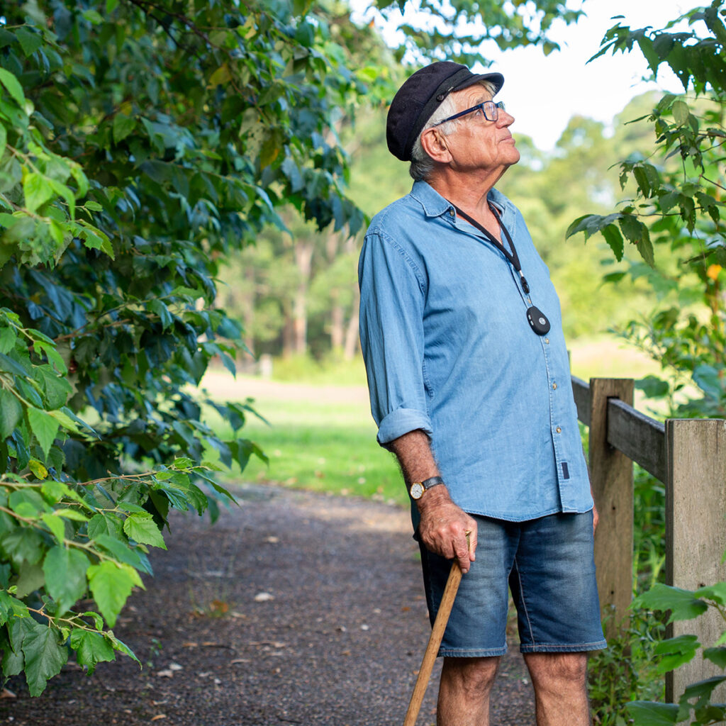 Senior man wearing his vital call emergency personal medical alarm.