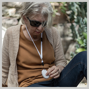Senior lady wearing a Live Life alarm pendant