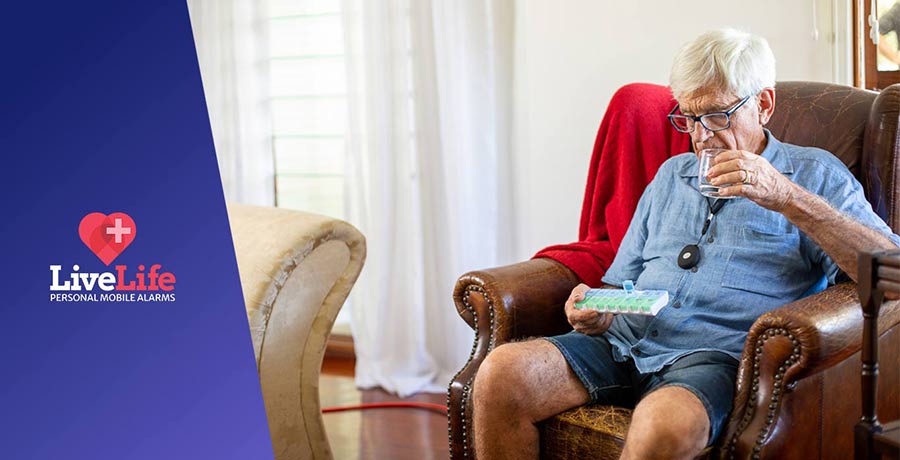 Elderly Australian sitting in couch wearing his 4GX LiveLife Alarm