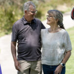 senior man and lady wearing Live Life Alarm pendants and watches outdoors